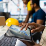 African american expert implementing automation logic in solar factory software, working on manufacturing solar power designs for eco friendly renewable energy. High tech production.